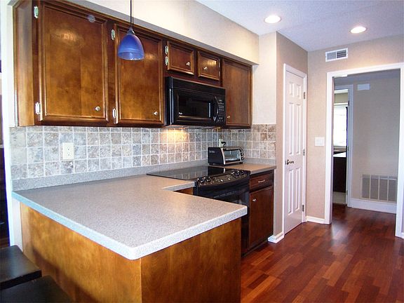 Gourmet kitchen with hardwood floors and tiled back splash.