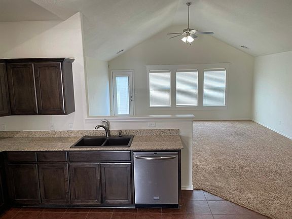 Open concept living area and kitchen; vaulted ceiling in living room; lots of natural light; ceiling fan in living room