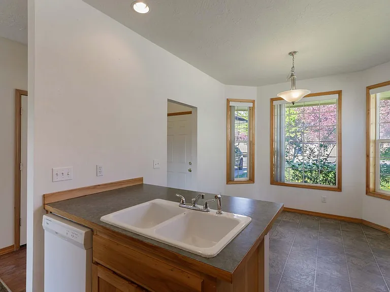 Kitchen with eating area and lots of light. Countertops upgraded to granite since photo was taken.
