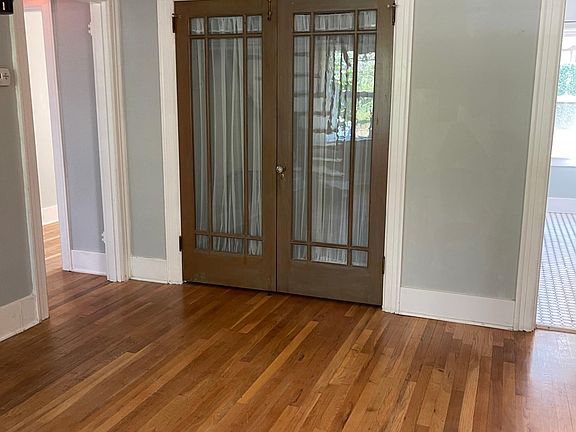 Original dual 9-panel glass doors open to a large walk-in closet with custom crown moulding around the living room.