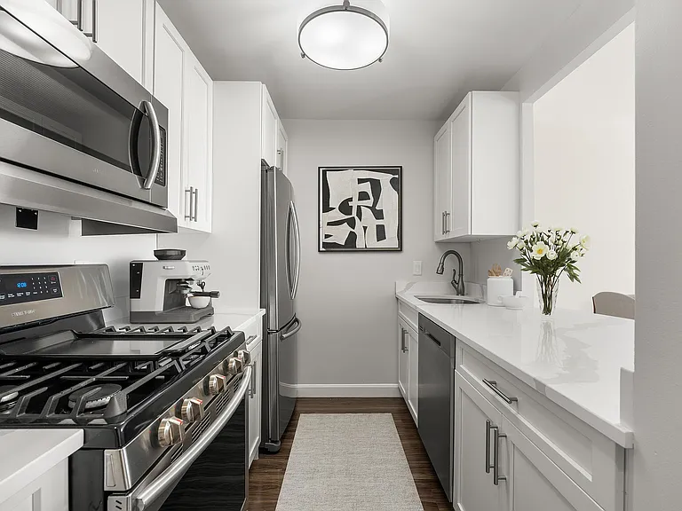 Sleek modern kitchen, statuario quartz countertops, six burner gas stove, stainless steel appliances at Parkside Place, apartments in Cambridge, MA