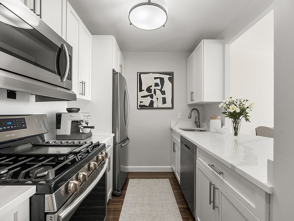 Sleek modern kitchen, statuario quartz countertops, six burner gas stove, stainless steel appliances at Parkside Place, apartments in Cambridge, MA