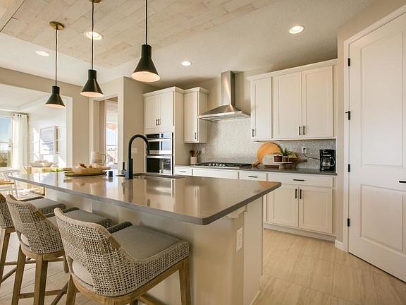 Beautiful brand new kitchen shown with a modern look of white cabinetry, gray countertops, and black