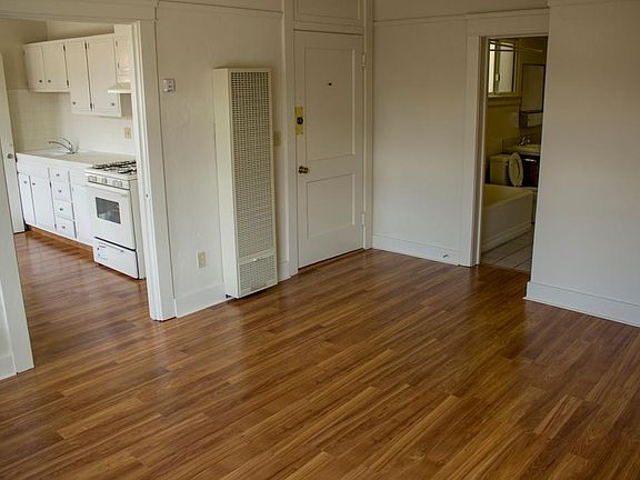 Living Room, facing kitchen, front door and bathroom.