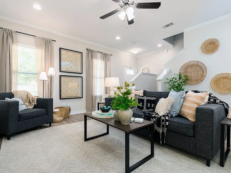 Unwind in a Stylish Living Room with Ceiling Fan and Elegant Curtains at Seaglass Apartments