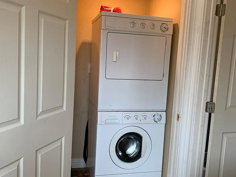 private laundry room with stacker washer dryer