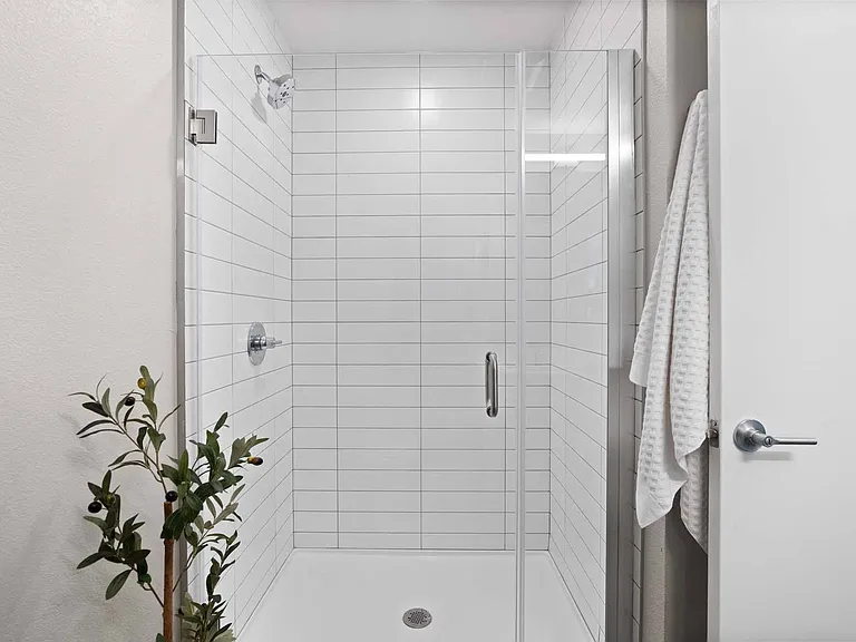Indulge in a refreshing shower with a sleek glass door for a modern touch.