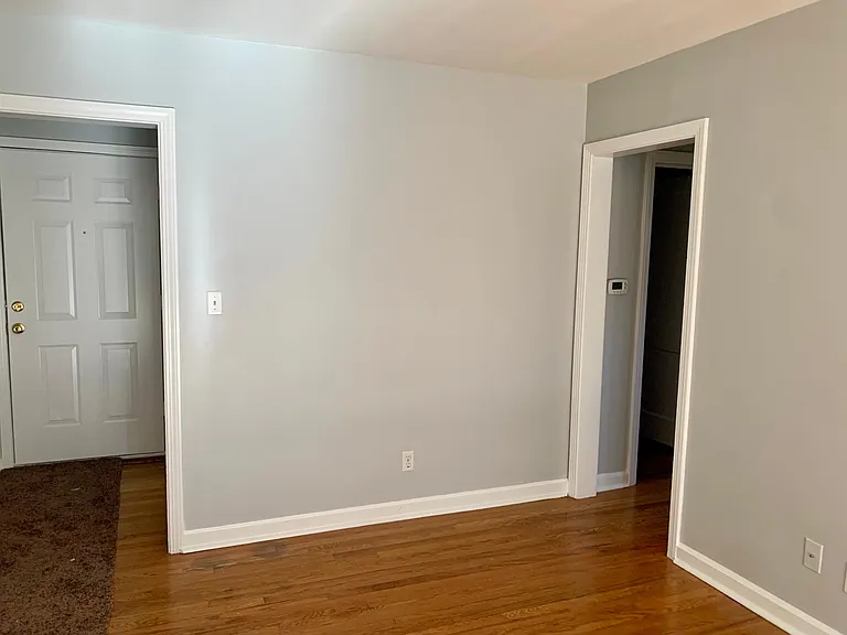 Livingroom with front door of the left and hallway to bedrooms on the right