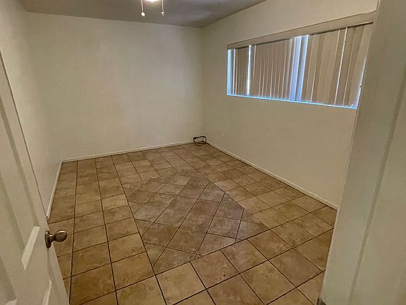 Bedroom one with tile floors customized closet and ceiling fan
