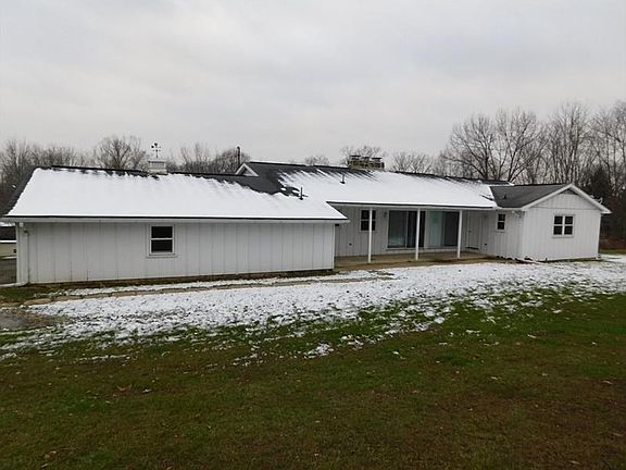 Rear view of home showing covered patio and attached shed by the garage.