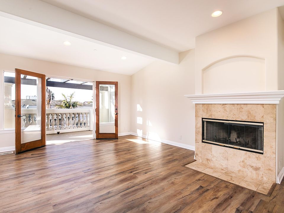 Living room with fireplace and french doors that lead to a large balcony