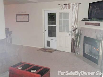 Living room
						:
						Carpet, Fireplace, Back door has a screen door with doggie door.