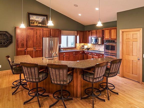 The heart of the home on the main floor includes this gourmet kitchen with large island with breakfast bar, Cambria countertops, and walk in pantry.