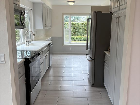 Kitchen breakfast nook and window seat overlooks the yard. Solid surface white countertops. Refrigerator included.