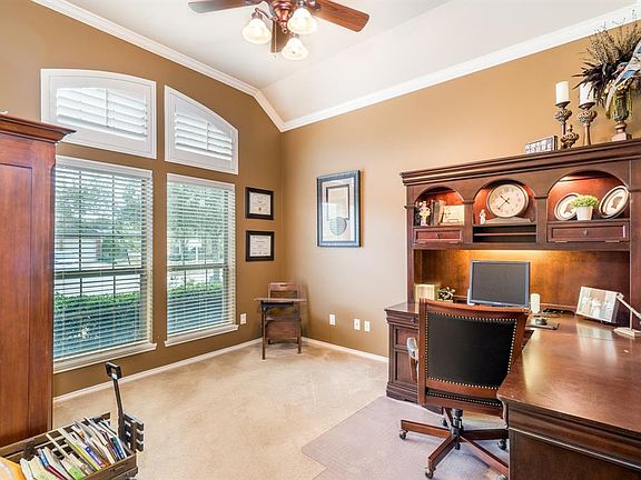 The front room to the left of the entry is this homeowner's study. Another use would be as a formal living room. Note the transom windows shaded with plantation shutters. This home features a number of transom windows that let in lots of natural ligh