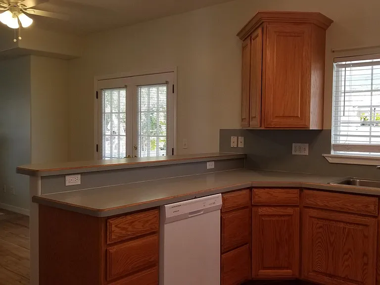 View of kitchen looking toward family room with fireplace.