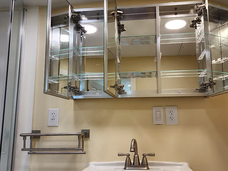Mirrored inside and out, medicine cabinet doors open