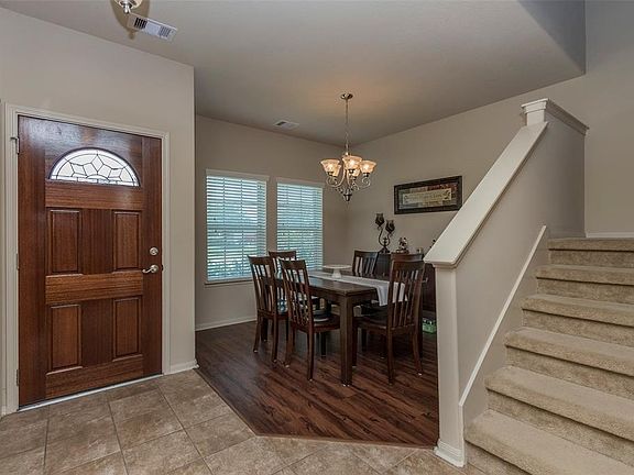 Entry welcomes you with a view to the family room and access to utility, dining, and upstairs.