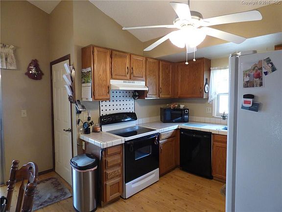 spacious kitchen with ceiling fan, and walk out to patio