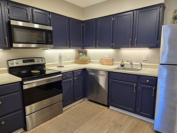 Stylish kitchen with rich navy cabinets, stainless steel appliances, and a practical layout for everyday cooking and entertaining. Brand-new countertops and sink installed since photos were taken.