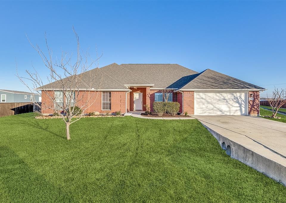 Ranch-style home with a garage and a front lawn