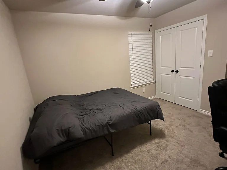 Carpeted bedroom with ceiling fan, window blinds, and double-door closet for convenient storage and comfortable daily living.