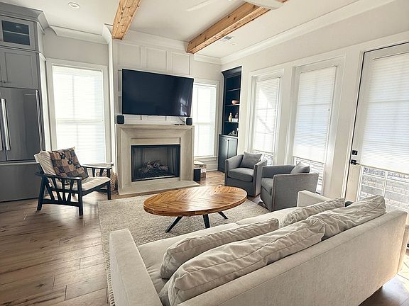 Living room with flat screen and Apple Home Pod speakers. Remote control gas fireplace