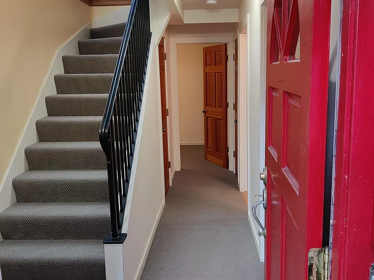 Front door, lower floor hallway, stairs to upper floor