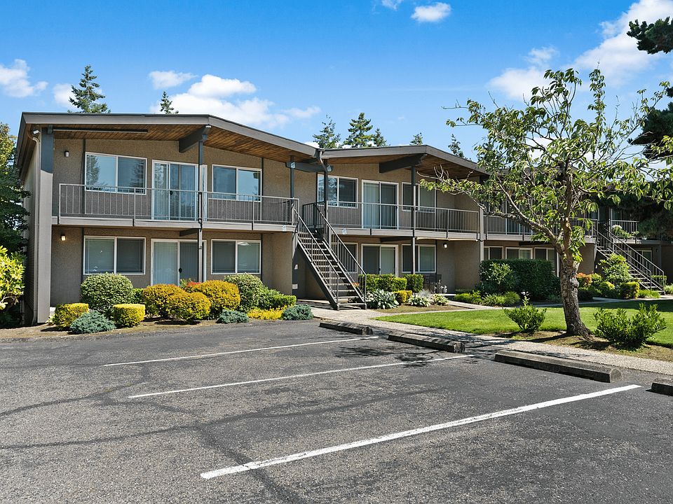 Charming two-story apartment building with lush landscaping and convenient parking.