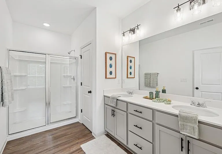 Primary bathroom with double vanity, and walk-in shower.