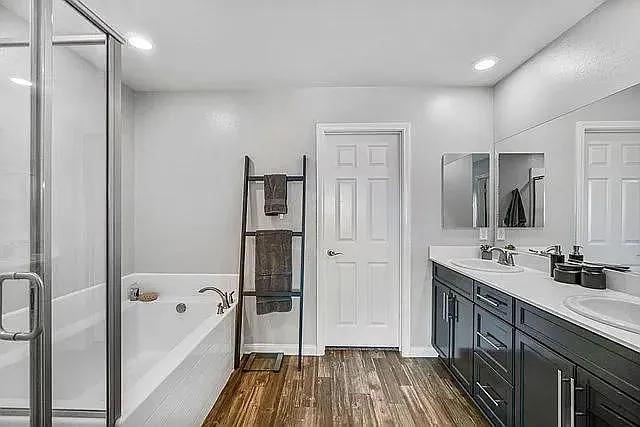 Primary bedroom's massive bathroom with shower, bathtub, and walk-in closet.