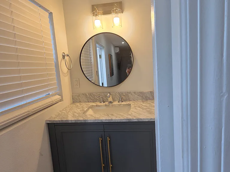 Well-lit bathroom with warm light and ventilated window.