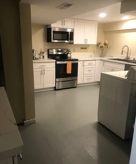 kitchen with oven, microwave, sink, dishwasher, and washer & dryer