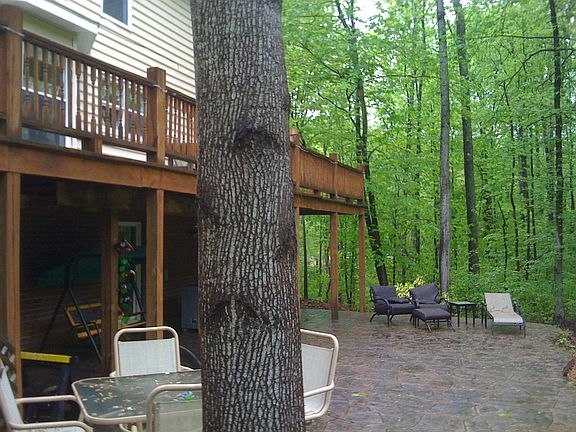custom patio beneath deck w/doors to entertainment room and gym