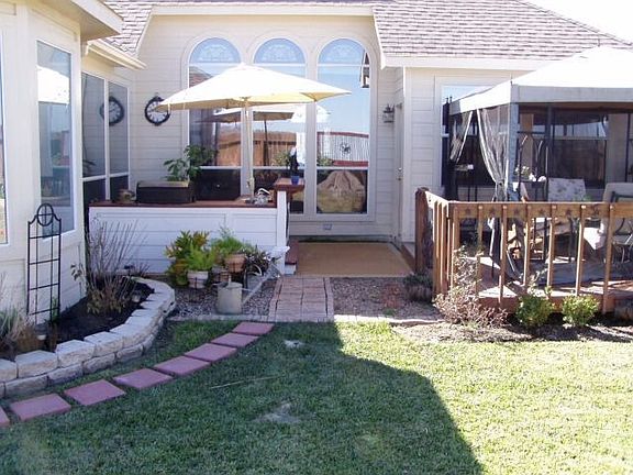 Back yard with outdoor kitchen, canopied deck, fountains, sprinkle system