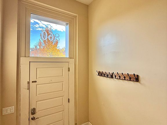 Private and secure, light filled entry foyer with coat racks and coat closet