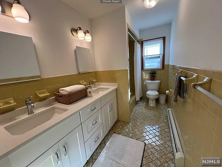 Redone bathroom with linen closet, many drawers to accompany the double sinks, bathtub and shower.