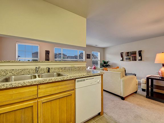 A kitchen with lots of cabinet storage, double sinks, and granite countertops