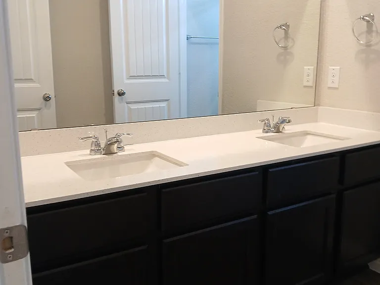 Common upstairs bathroom features a double vanity with a door separating the shower and toilet for additional privacy.