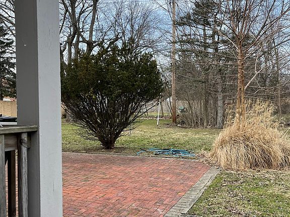 Large backyard with porch and brick patio