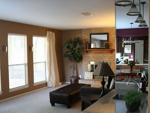 view into family room with mirrored wall wetbar with granite countertop