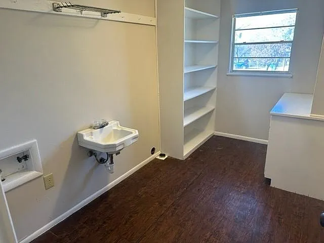 Large laundry room with sink , shelving and built-in desk and cabinets