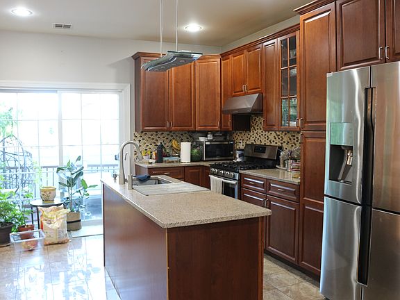 Open kitchen layout with stainless steel appliances with walk out deck door