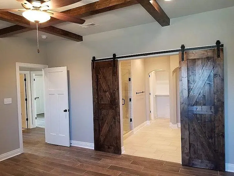 barn doors opening from main bedroom into main bath