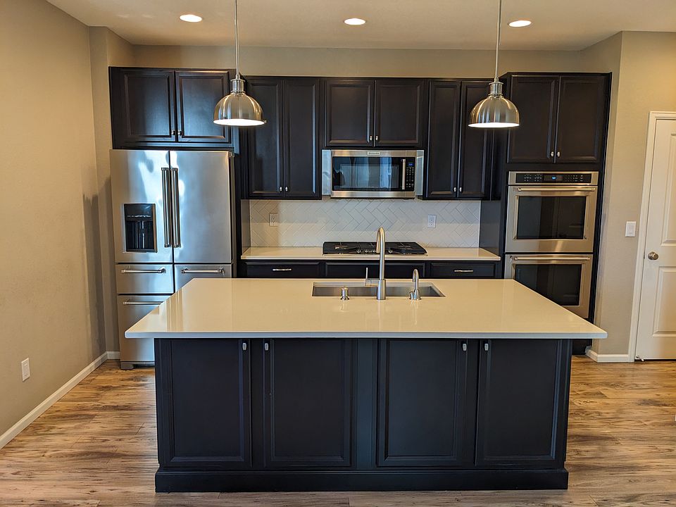 Kitchen has high-end stainless steel appliances and two storage pantries