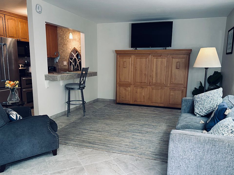 Living toom with couch, recliner chair, breakfast bar and TV with internet