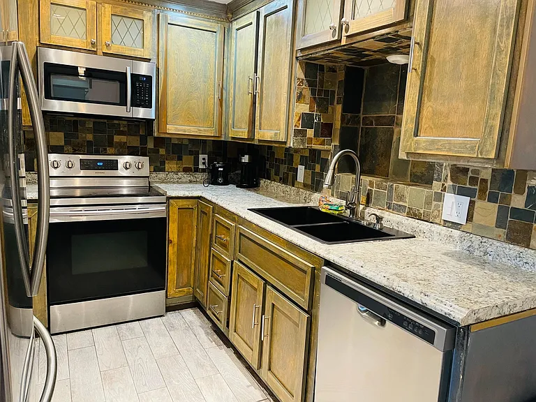 Kitchen with major and small appliances and cooking basics. Pots, plates and silverware