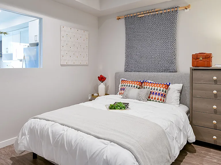 Large bedrooms with an interior window that brings light from the living area into the bedroom space