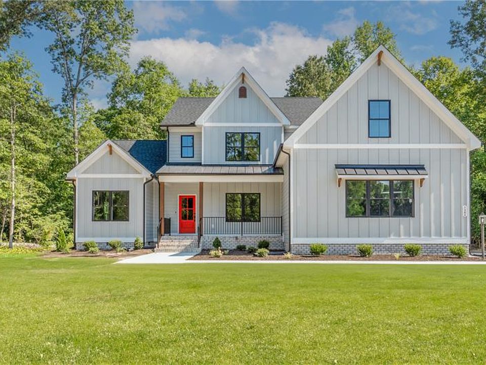 Modern farmhouse in Scotchtown Estates with gray siding, black roof, large windows, and a bright red
