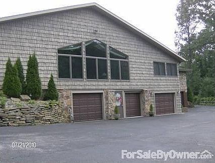 Rear view of Great Room and Garages
						:
						parking area,circular driveway, lower-level entrance and partial view of garages